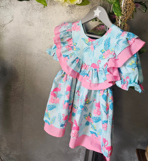 rochie din bumbac organic certificat oeko tex pentru fetite și bebeluși cu imprimeu flamingo și frunze verzi pe fond albastru și cu alt strat de bumbac roz pe dedesubt